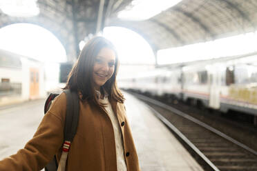 Portrait of smiling young woman at the train station - VABF02498