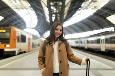 Portrait of smiling young woman at the train station - VABF02514