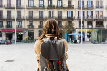 Rear viewof young woman with backpack in the city, Barcelona, Spain - VABF02523