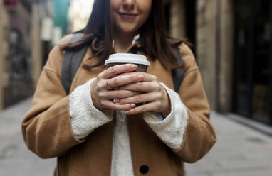 Close-up of young woman with takeaway coffee in the city, Barcelona, Spain - VABF02540