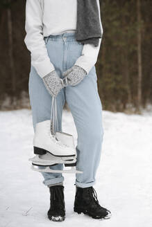 Crop-Ansicht einer Frau mit Schlittschuhen im Winter - EYAF00810