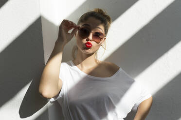 Porträt einer jungen Frau mit roten Lippen und Sonnenbrille, die den Mund aufreißt - JPTF00440