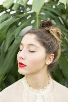 Porträt einer jungen Frau mit roten Lippen und geschlossenen Augen, die sich entspannt - JPTF00446