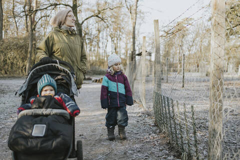 Mother with daughters during forest walk in autumn stock photo