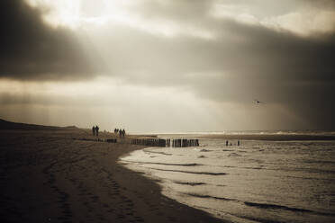 Deutschland, Schleswig-Holstein, Sonnenlicht durchdringt Wolken über Sandstrand der Insel Sylt in der Abenddämmerung - ANHF00142