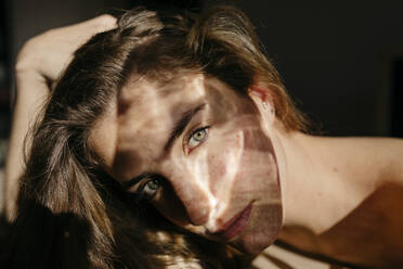 Porträt einer jungen Frau mit Lichtreflexion auf ihrem Gesicht - TCEF00039