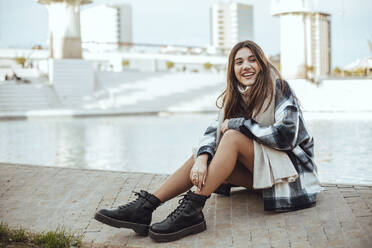 Young brunette woman wearing black and white coat and scarf in the city - ACPF00658