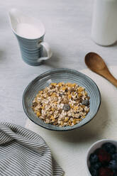 Schale mit Müsli und Joghurtbecher im Hintergrund - JMHMF00035