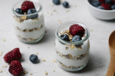 Kleine Gläser mit Müsli, Joghurt, Blaubeeren und Himbeeren - JMHMF00037