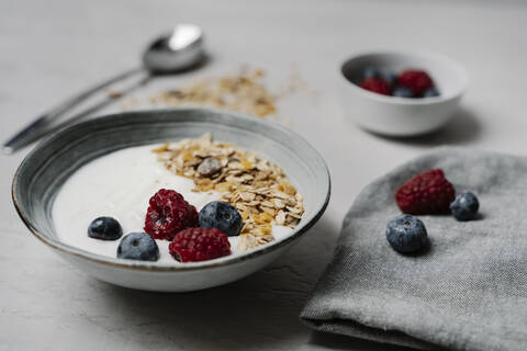 Bowl of granola with yogurt, blueberries and raspberries stock photo