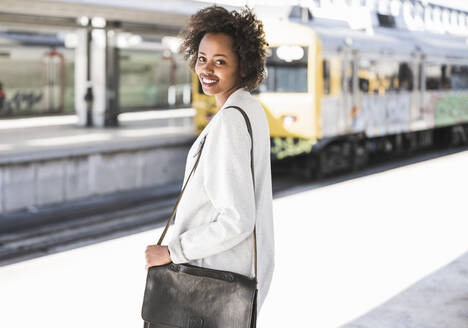 Portrait of smiling young woman at the train station - UUF20158