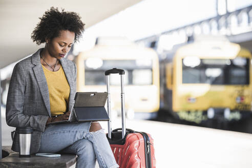 Young businesswoman using tablet at the train station - UUF20176