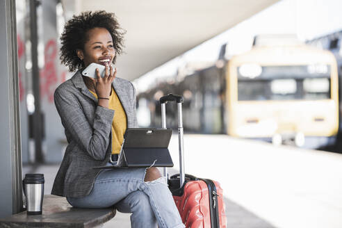 Young businesswoman using tablet and smartphone at the train station - UUF20178