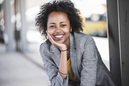 Portrait of smiling young businesswoman at the train station - UUF20205