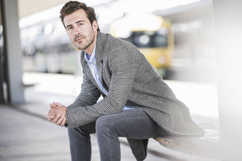 Porträt eines jungen Geschäftsmannes auf dem Bahnhof, lizenzfreies Stockfoto