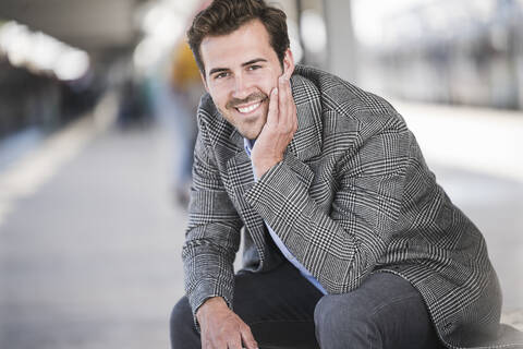 Portrait of smiling young businessman at the train station stock photo