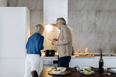 Älteres Paar bereitet Abendessen in der Küche zu Hause vor - SODF00598