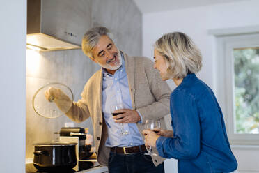 Mature couple preparing dinner in kitchen at home - SODF00600