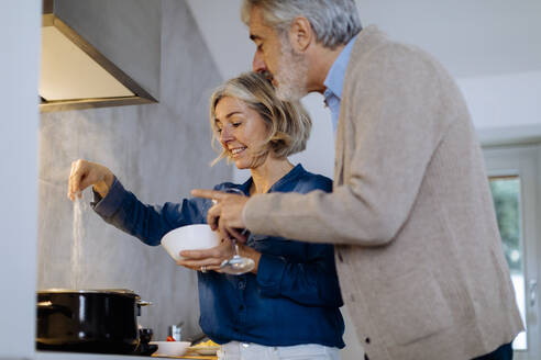 Älteres Paar bereitet Abendessen in der Küche zu Hause vor - SODF00602