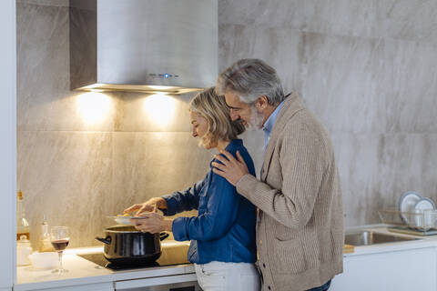 Älteres Paar bereitet Abendessen in der Küche zu Hause vor, lizenzfreies Stockfoto