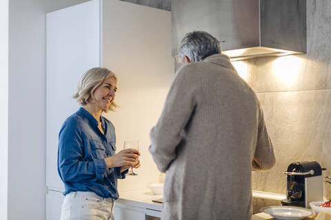 Mature couple preparing dinner in kitchen at home stock photo