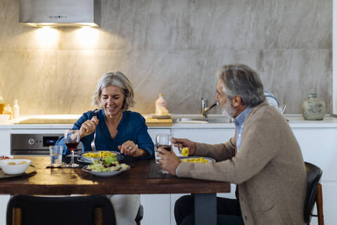 Älteres Paar beim Abendessen in der Küche zu Hause - SODF00619