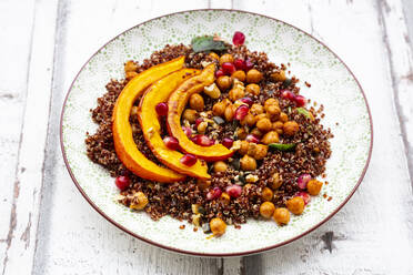 Studio shot of salad of red quinoa with baked pumpkin, chickpeas, pomegranate, basil, walnuts and pumpkin seeds - LVF08527