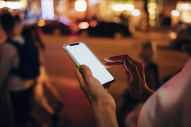 Hands of woman holding smartphone at night, close-up - OYF00088