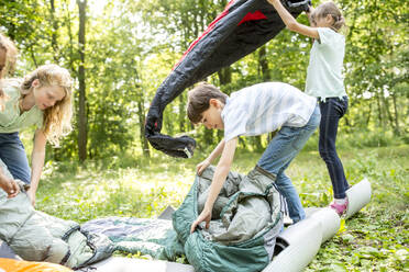 Schulkinder packen ihre Schlafsäcke aus, um im Wald zu zelten - WESTF24491