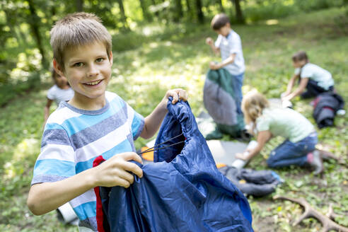 Schulkinder packen ihre Schlafsäcke aus, um im Wald zu zelten - WESTF24493