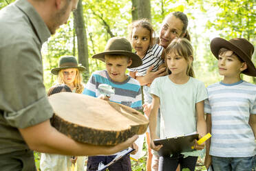 School children examining annual rings of a tree trunk - WESTF24508