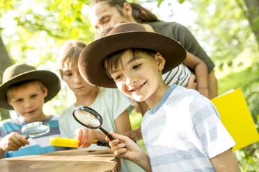 Schulkinder untersuchen die Jahresringe eines Baumstamms - WESTF24510