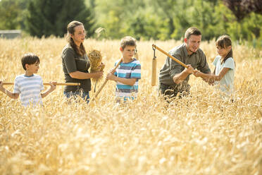 Kinder lernen auf einem Feld, wie man Weizen drischt - WESTF24533