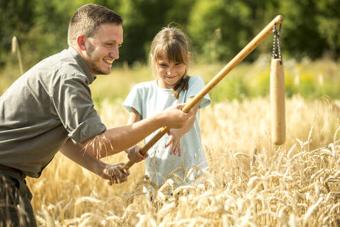 Kinder lernen auf einem Feld, wie man Weizen drischt - WESTF24534