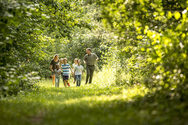 School children walking in forest with their teacher - WESTF24540