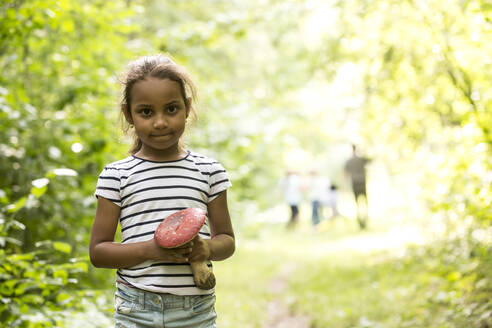 Kleines Mädchen steht im Wald und hält Fliegenpilz - WESTF24541