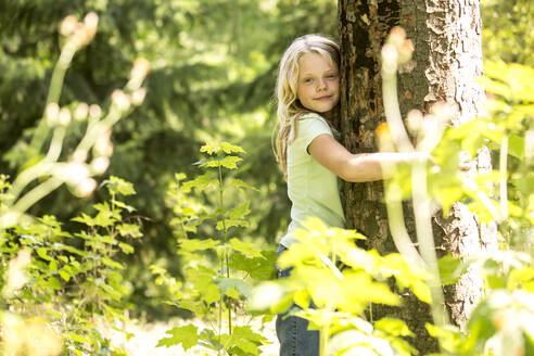 Kleines Mädchen umarmt Baum im Wald - WESTF24549