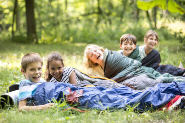 Schulkinder zelten im Wald, liegen in Schlafsäcken - WESTF24555