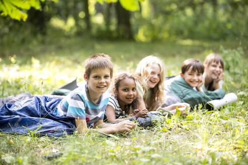 Schulkinder zelten im Wald, liegen in Schlafsäcken - WESTF24556