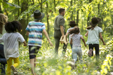 School children walking in forest with their teacher - WESTF24562