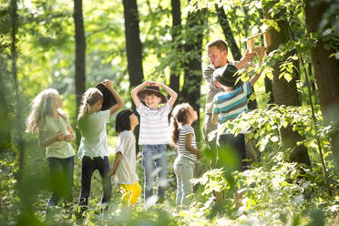 School children fixing a bidhouse on a tree - WESTF24563