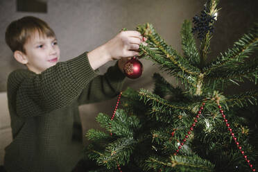 Boy decorating Christmas tree - EYAF00821