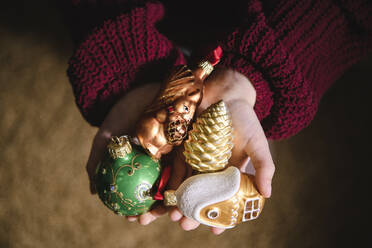 Various Christmas ornaments in girl's hand - EYAF00823