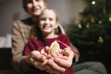 Female hand holding Christmas decorations. A star-shaped biscuit