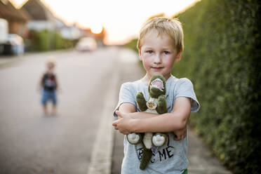 Boy holding stuffed dinosaur - JOHF05304