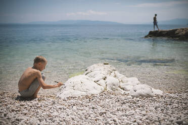 Boy playing on beach - JOHF05365