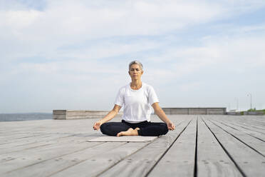 Frau übt Yoga auf dem Steg - JOHF05495