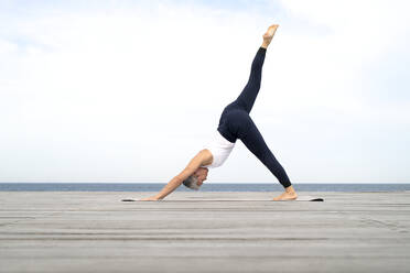 Frau übt Yoga auf dem Steg - JOHF05503