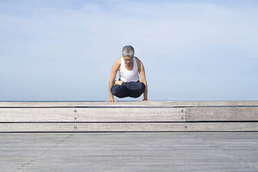 Frau übt Yoga auf dem Steg - JOHF05505