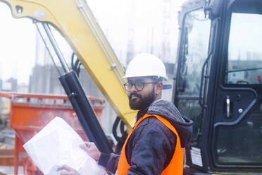 Construction engineer at construction site wearing hard hat and safety vest - SGF02582